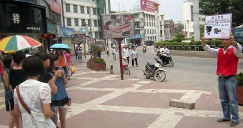 小伙街頭宣傳乙肝科普知識(shí) 高舉身份牌征人吃飯