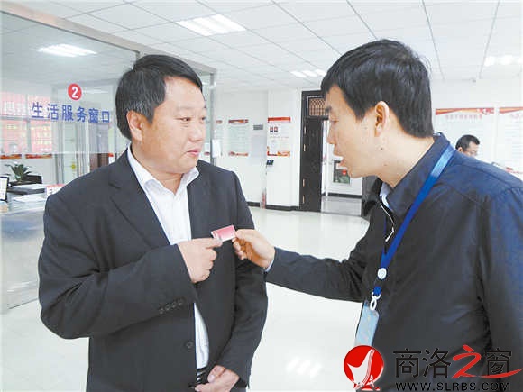 在鎮(zhèn)安縣新城社區(qū)便民服務(wù)大廳里，參會(huì)人員對(duì)社區(qū)工作人員掛牌上崗很感興趣。（記者 柯巖 攝）